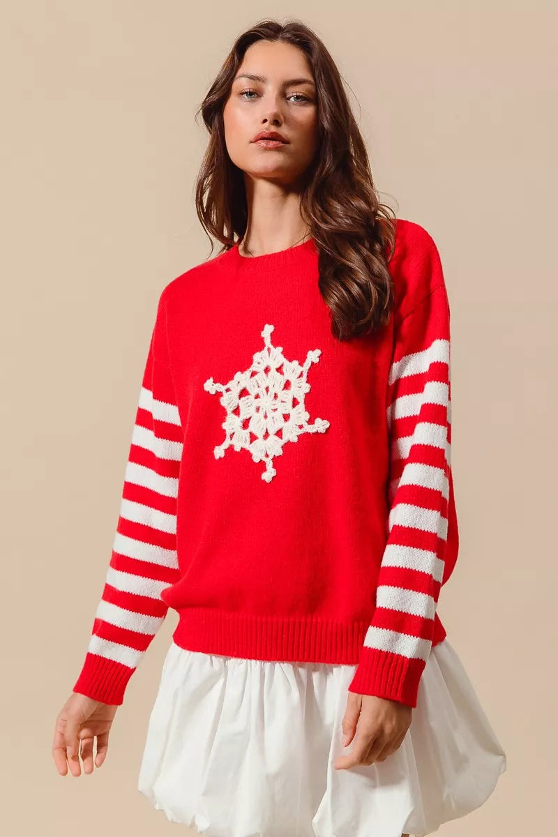 Woman wearing a red sweater with white snowflake design on a beige background