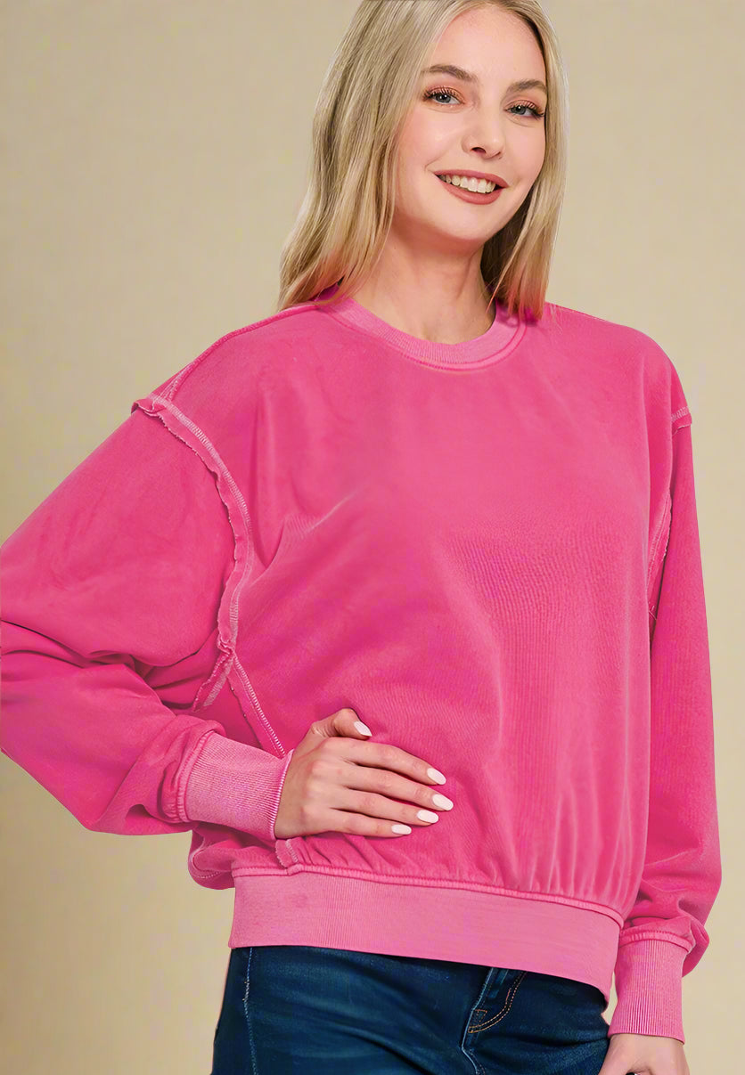 Woman wearing a bright pink sweatshirt on a white background