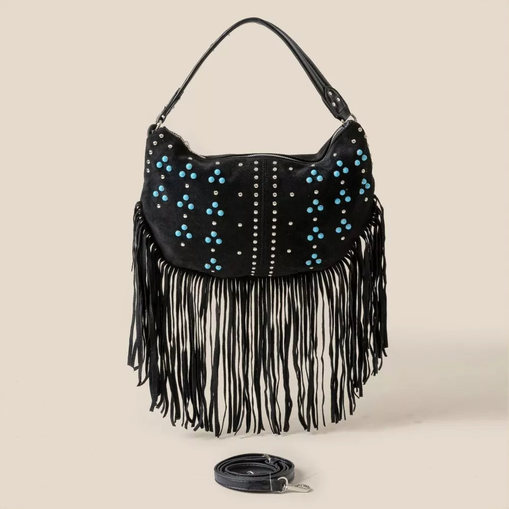 Black handbag with blue studs and fringes on a beige background