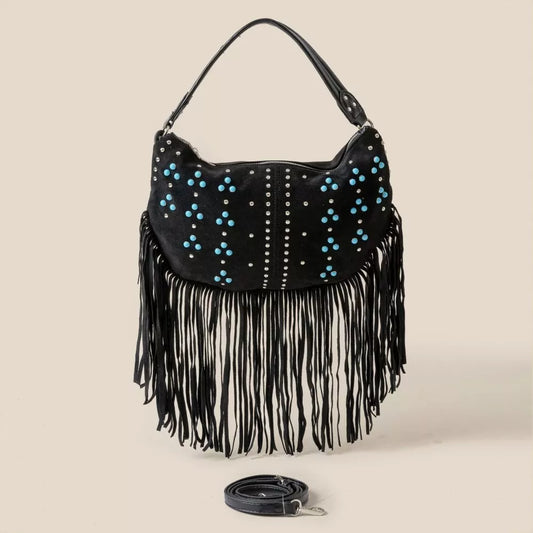 Black handbag with blue studs and fringes on a beige background