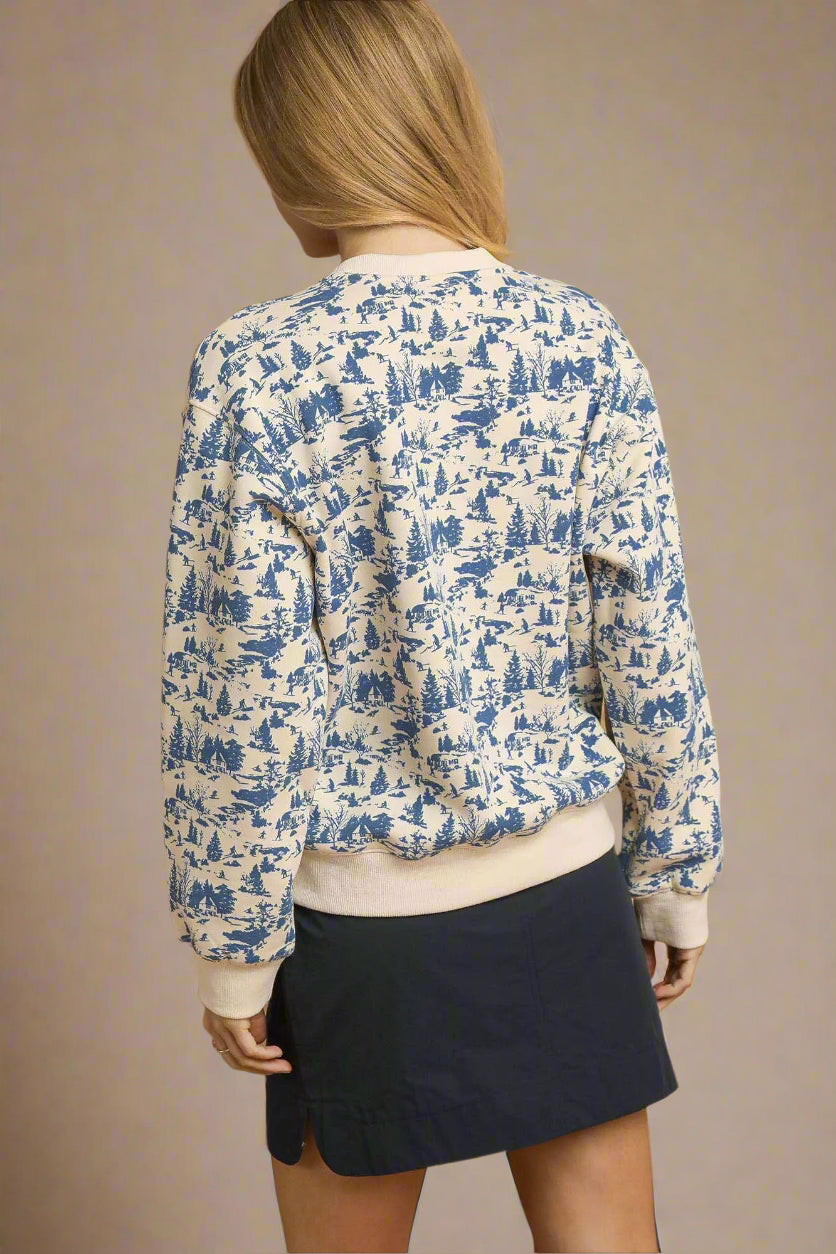 Person wearing a blue and white patterned shirt with a beige top and navy skirt on a beige background