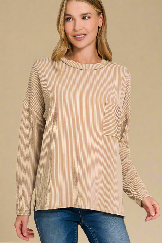 Woman wearing a light mocha sweater with a pocket on a beige background