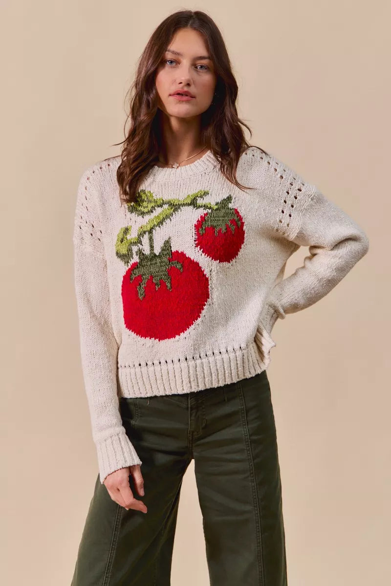Woman wearing a sweater with tomato design on a beige background