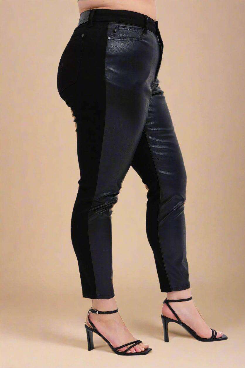 Black leather pants worn by a person on a white background