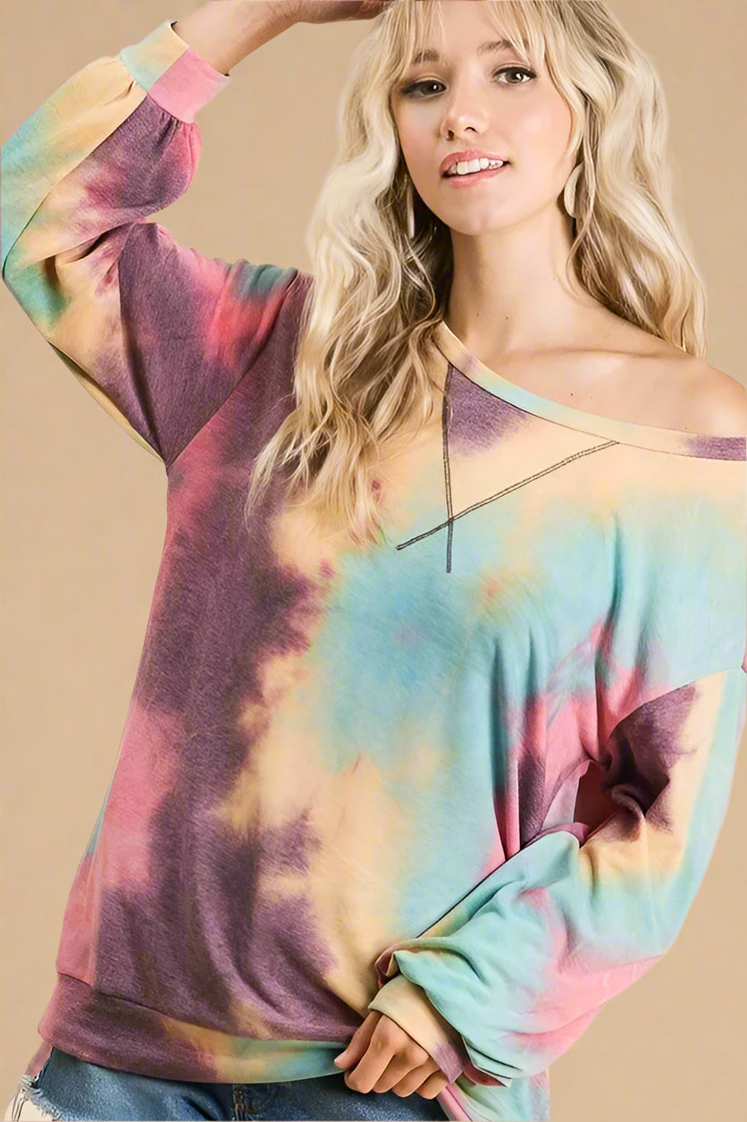 Woman wearing a colorful tie-dye sweater against a beige background