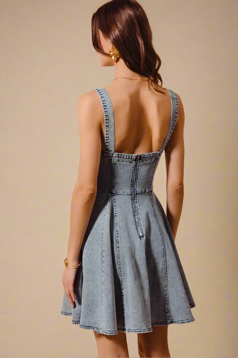 Woman wearing a denim dress with a beige background