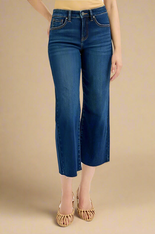 Blue jeans worn by a person on a beige background