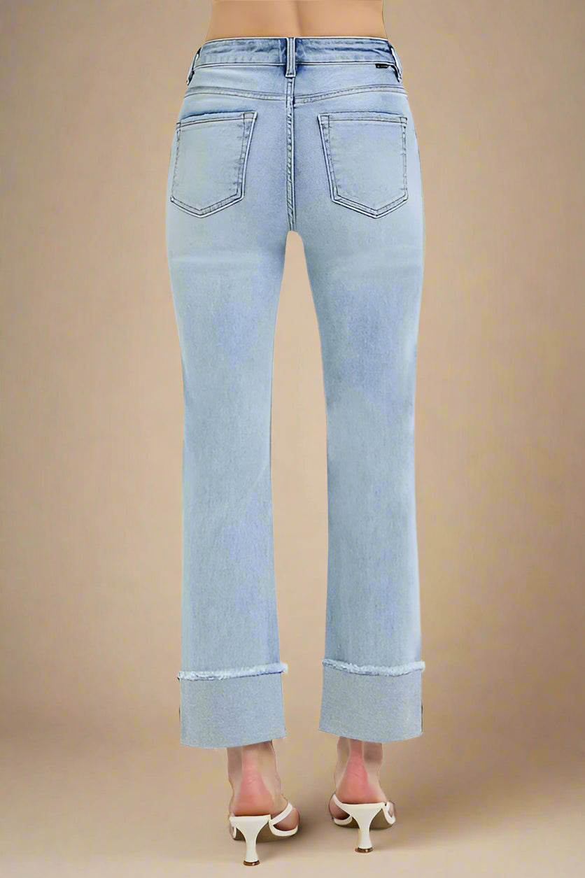 Light blue jeans worn by a person on a beige background