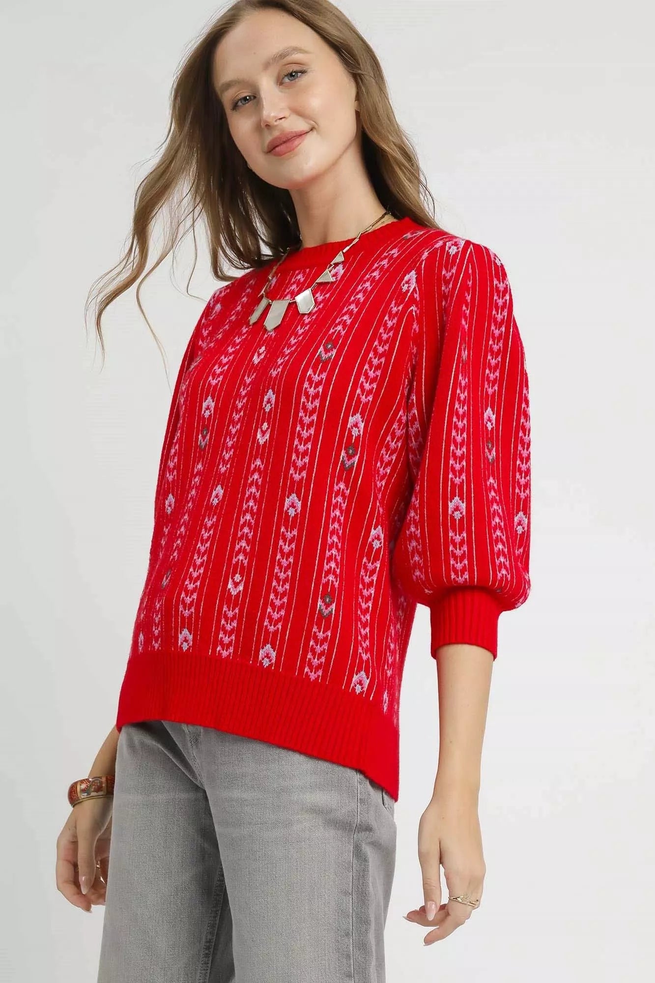 Woman wearing a red patterned sweater on a white background