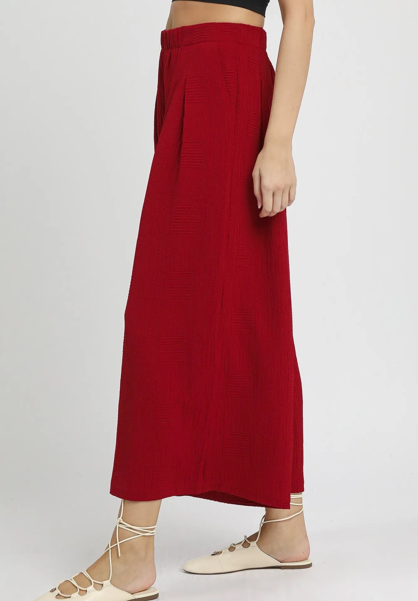 Red pants worn by a person on a white background