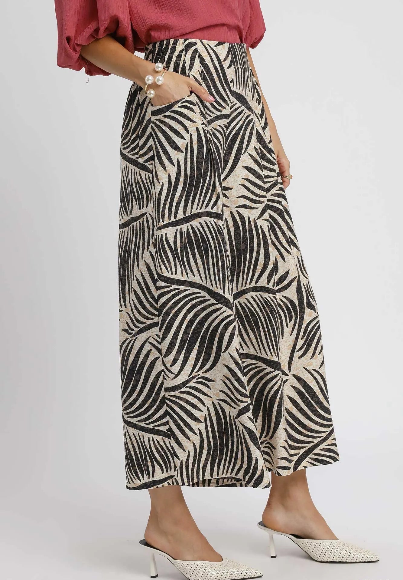 Person wearing a patterned skirt on a plain background