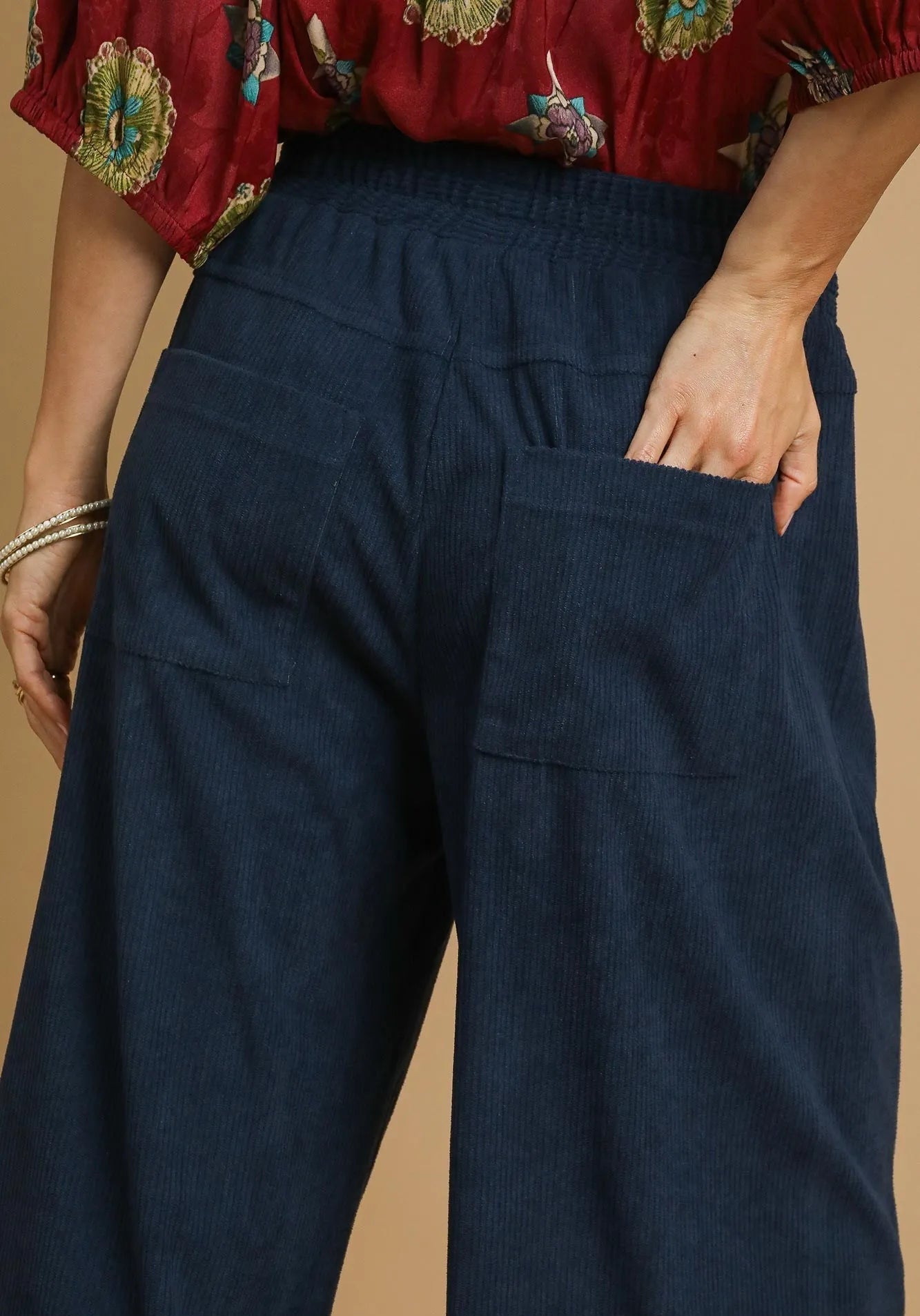 Navy blue pants worn by a person with a beige background