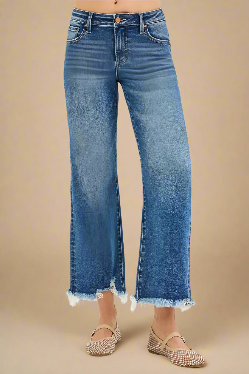 Blue jeans with a frayed hem on a beige background