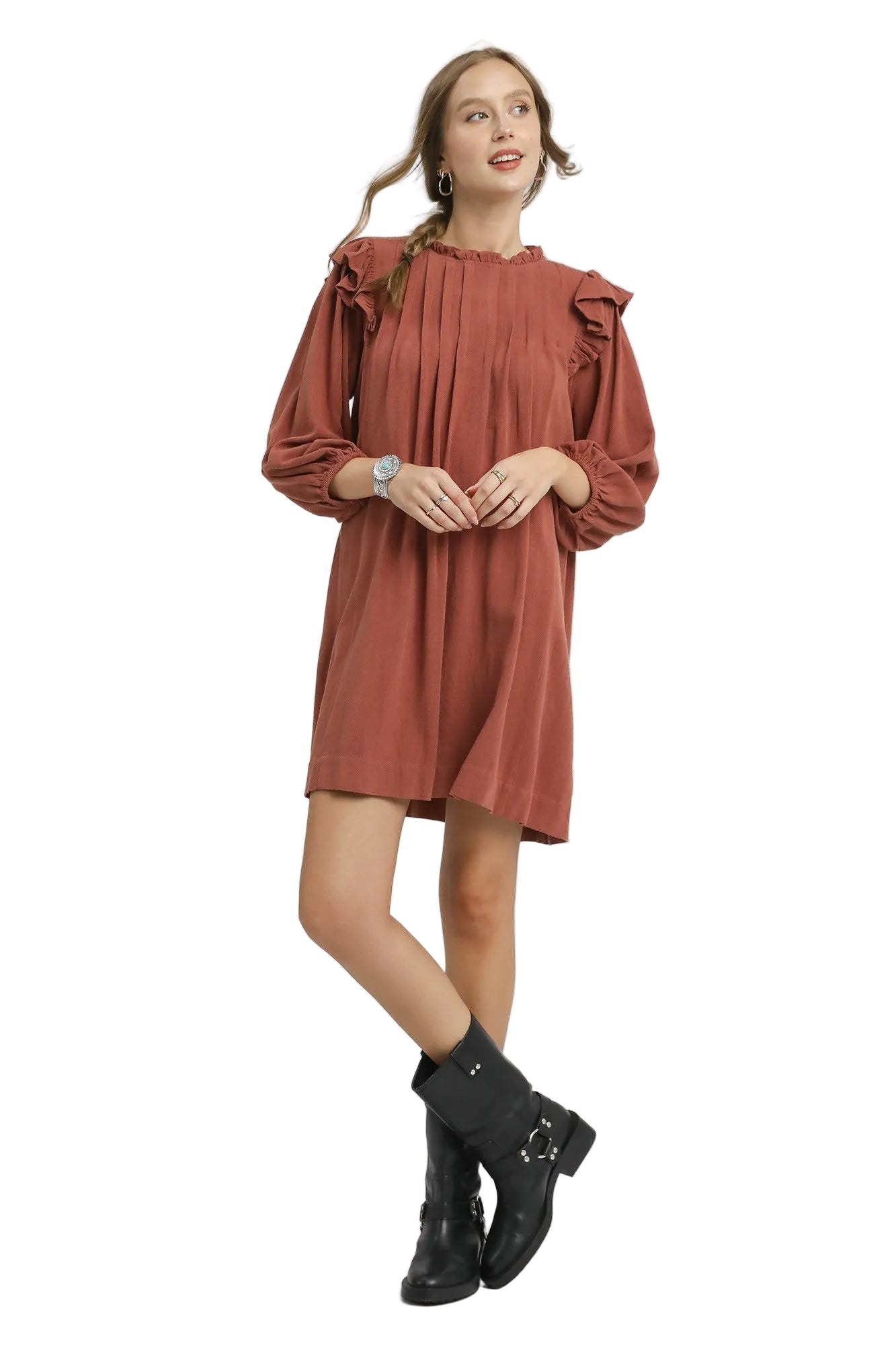 Woman wearing a rust-colored dress with ruffled sleeves on a white background