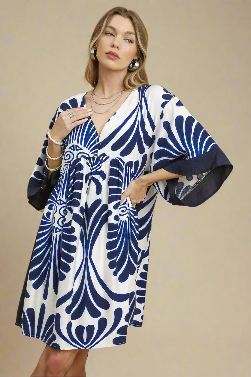 Woman wearing a blue and white patterned dress on a beige background