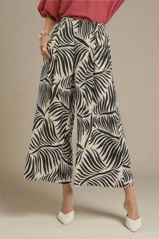 Person wearing wide-leg pants with a black and beige pattern on a white background