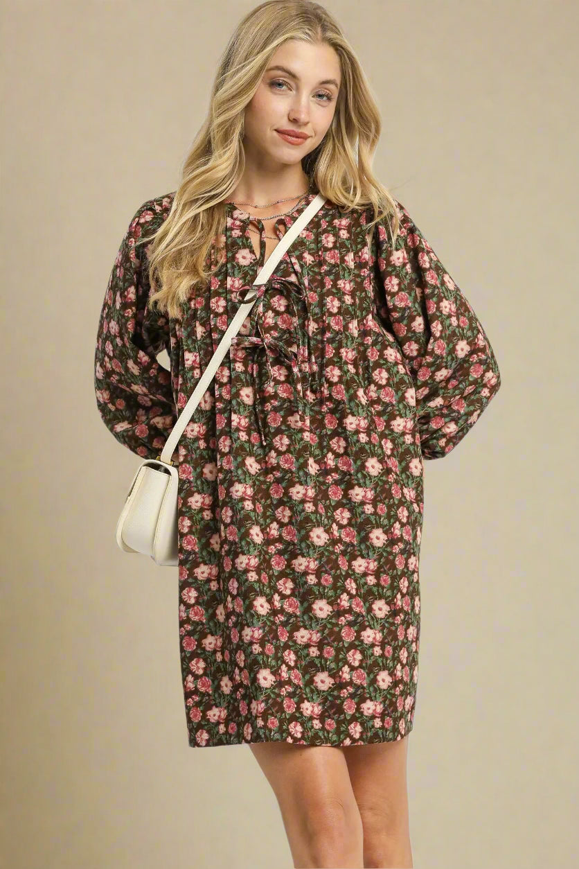 Woman wearing a floral dress with long sleeves on a white background