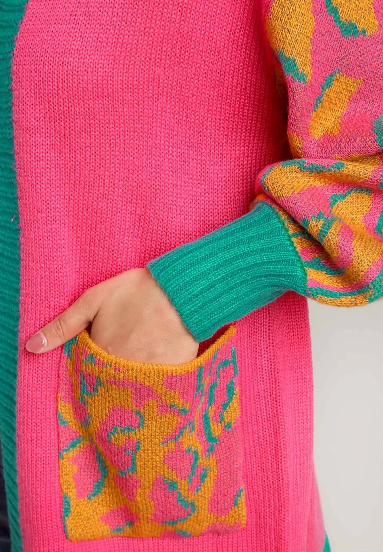 Close-up of a colorful sweater with a patterned pocket and vibrant colors.