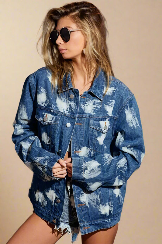 Woman wearing a blue denim jacket with white cloud pattern indoors.