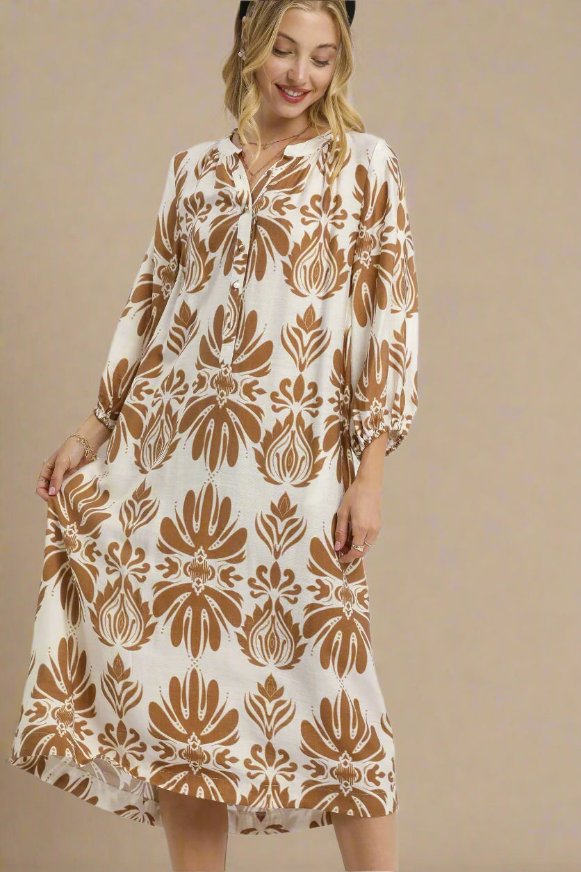 Woman wearing a beige and brown patterned dress on a white background