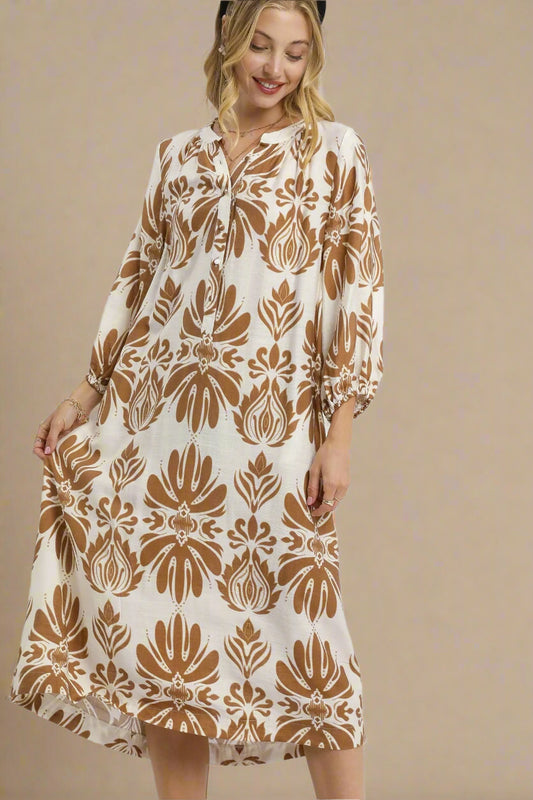 Woman wearing a beige and brown patterned dress on a white background