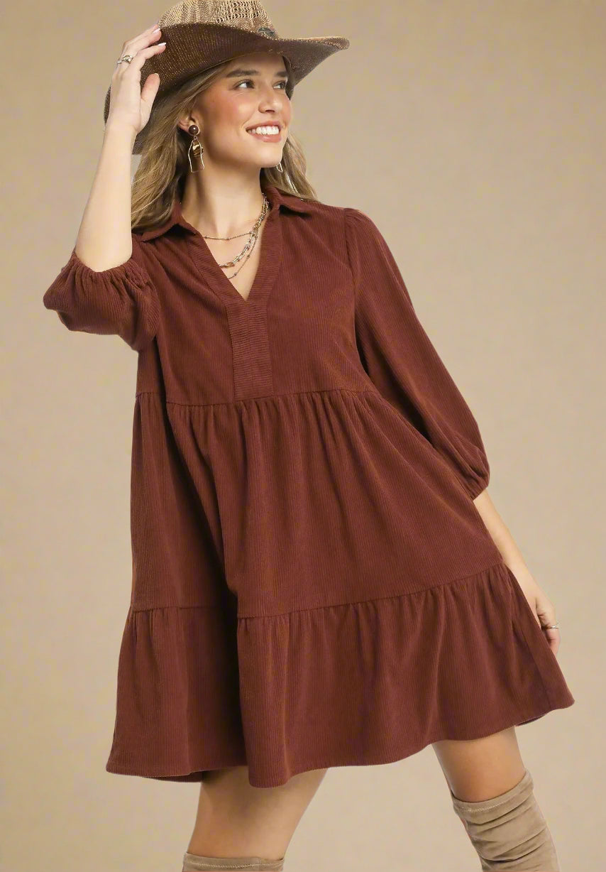 Woman wearing a brown dress with a beige background