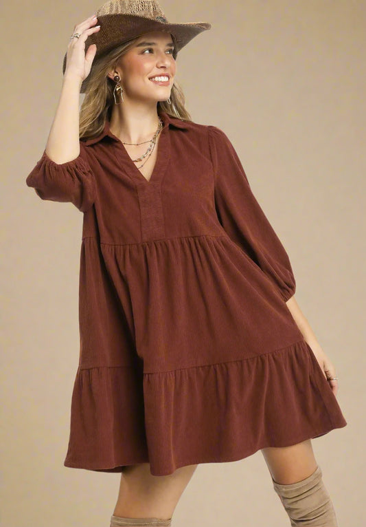 Woman wearing a brown dress with a beige background