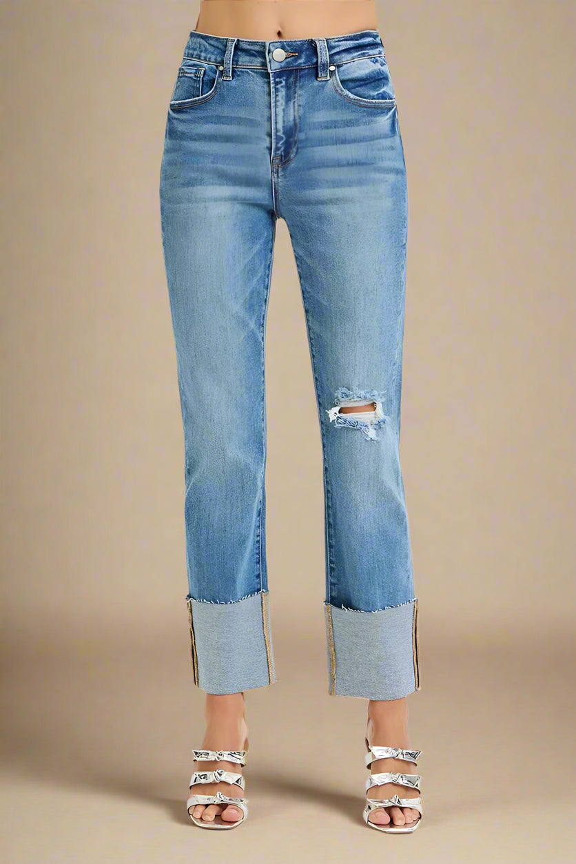 Blue jeans with a distressed hem on a white background