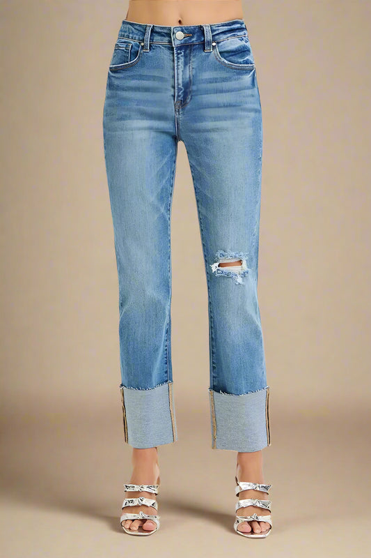 Blue jeans with a distressed hem on a white background