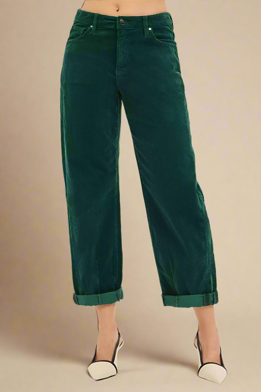 Green corduroy pants worn by a person on a white background