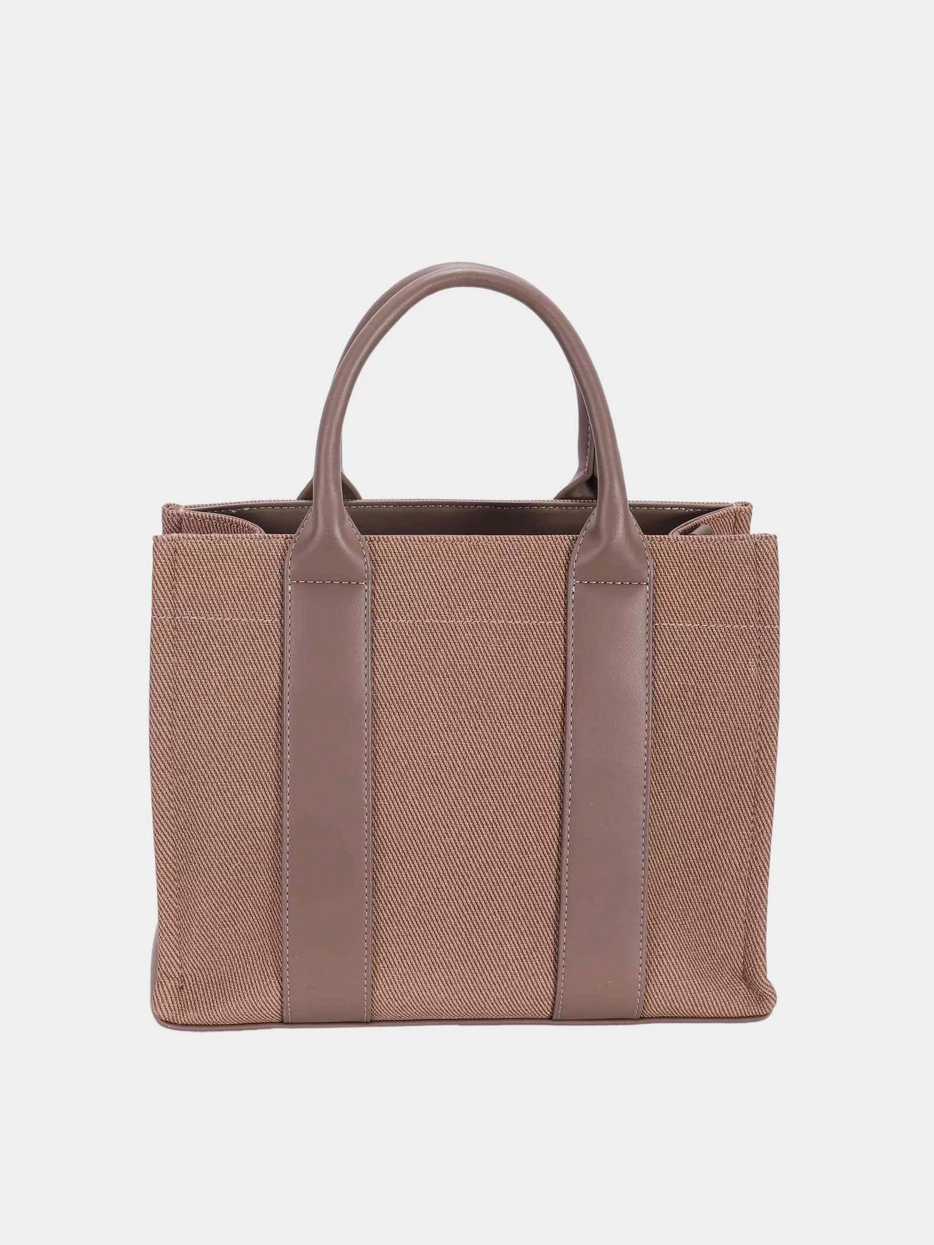 Brown tote bag with leather straps on a light gray background