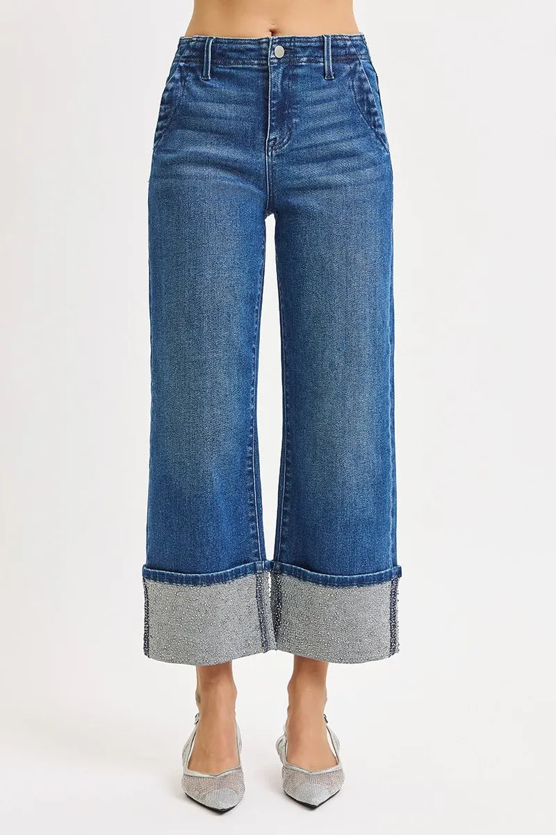 Blue jeans with a cuffed hem on a white background