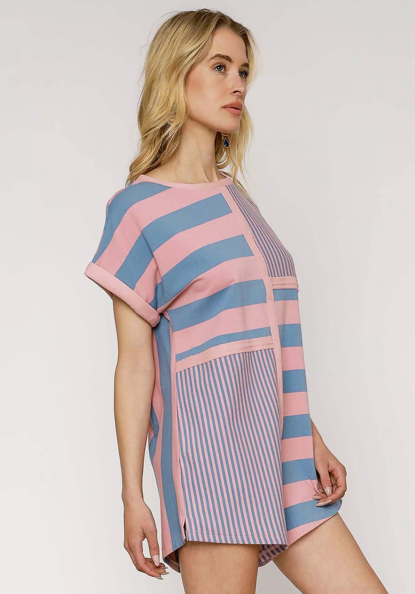 Woman wearing a striped romper with pink and blue colors on a white background