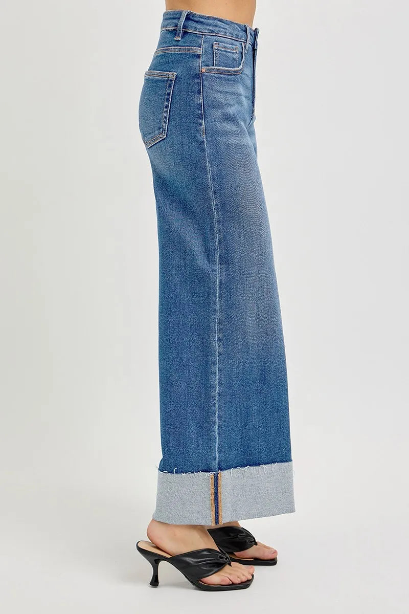 Blue jeans with a cuffed hem on a white background