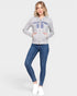 Woman wearing a gray hoodie with text and blue jeans on a white background