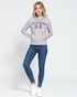 Woman wearing a gray hoodie with 'California 98' text and blue jeans on a white background