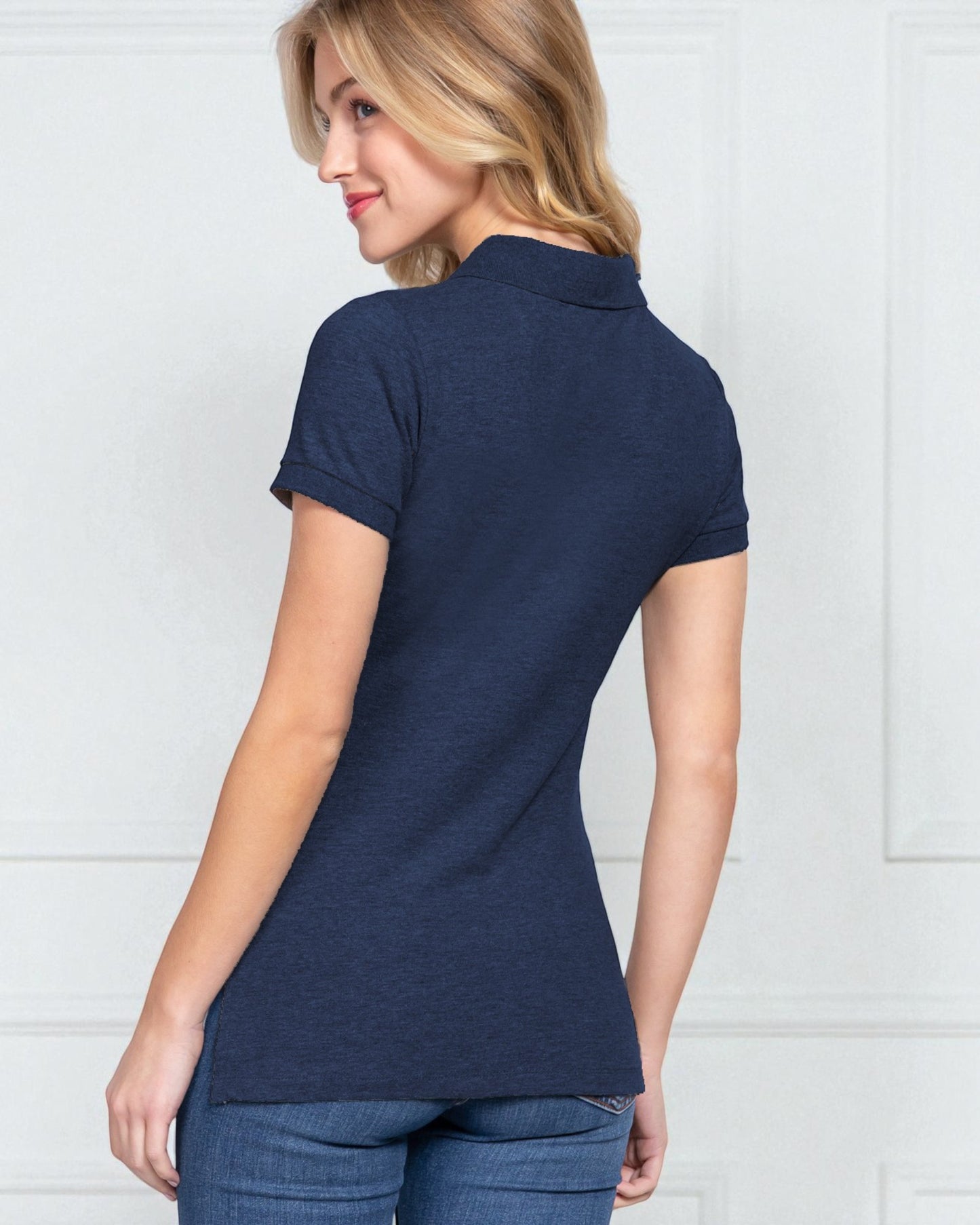 Woman wearing a navy blue polo shirt against a white background