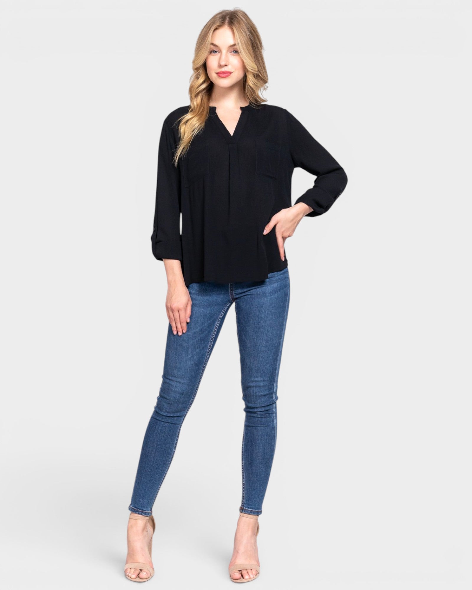 Woman wearing a black blouse and blue jeans on a white background