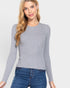 Woman wearing a gray sweater and blue jeans on a light gray background