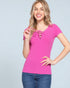 Woman wearing a bright pink lace-up top against a light gray background