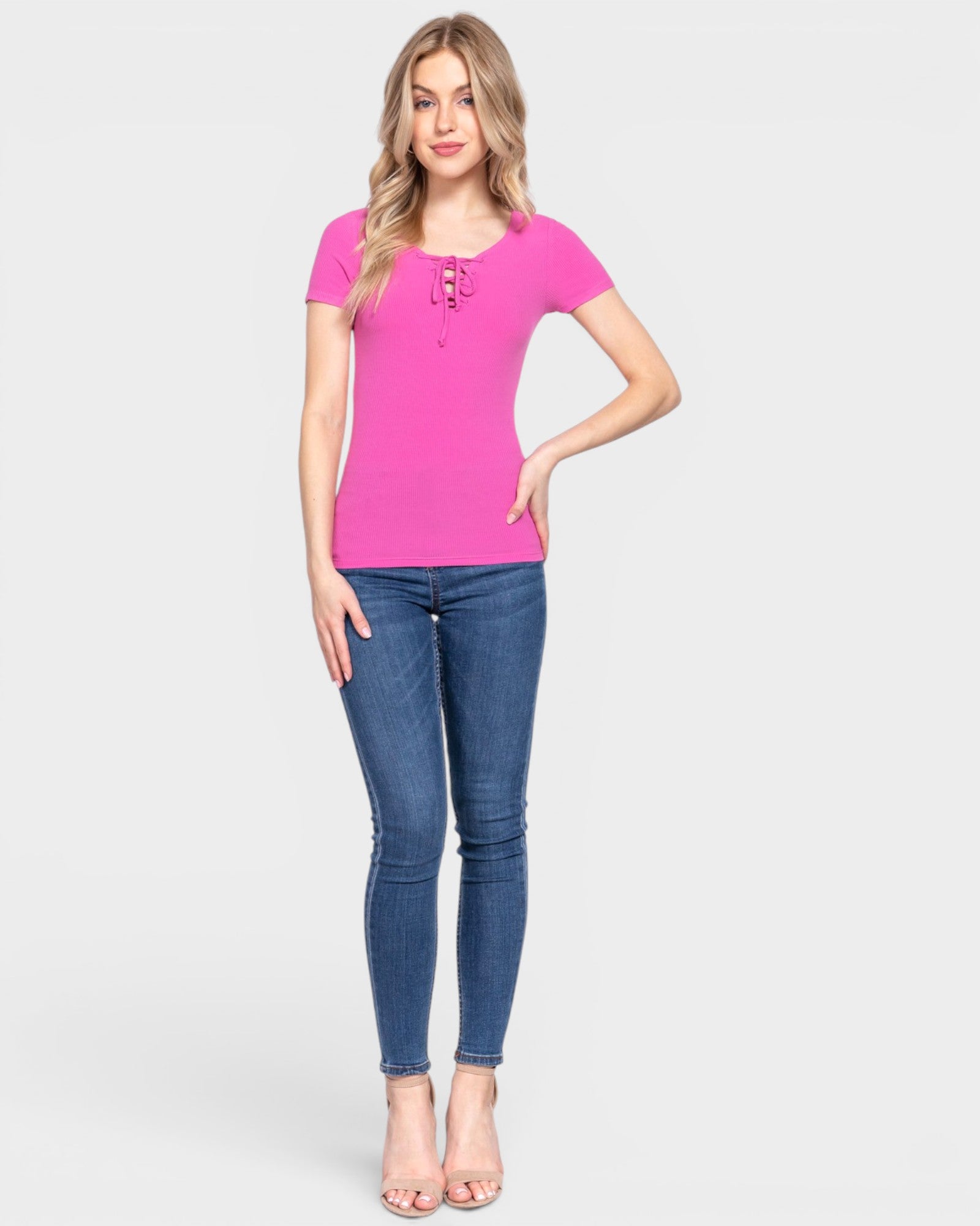 Woman wearing a pink top and blue jeans on a white background