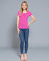 Woman wearing a pink top and blue jeans on a gray background