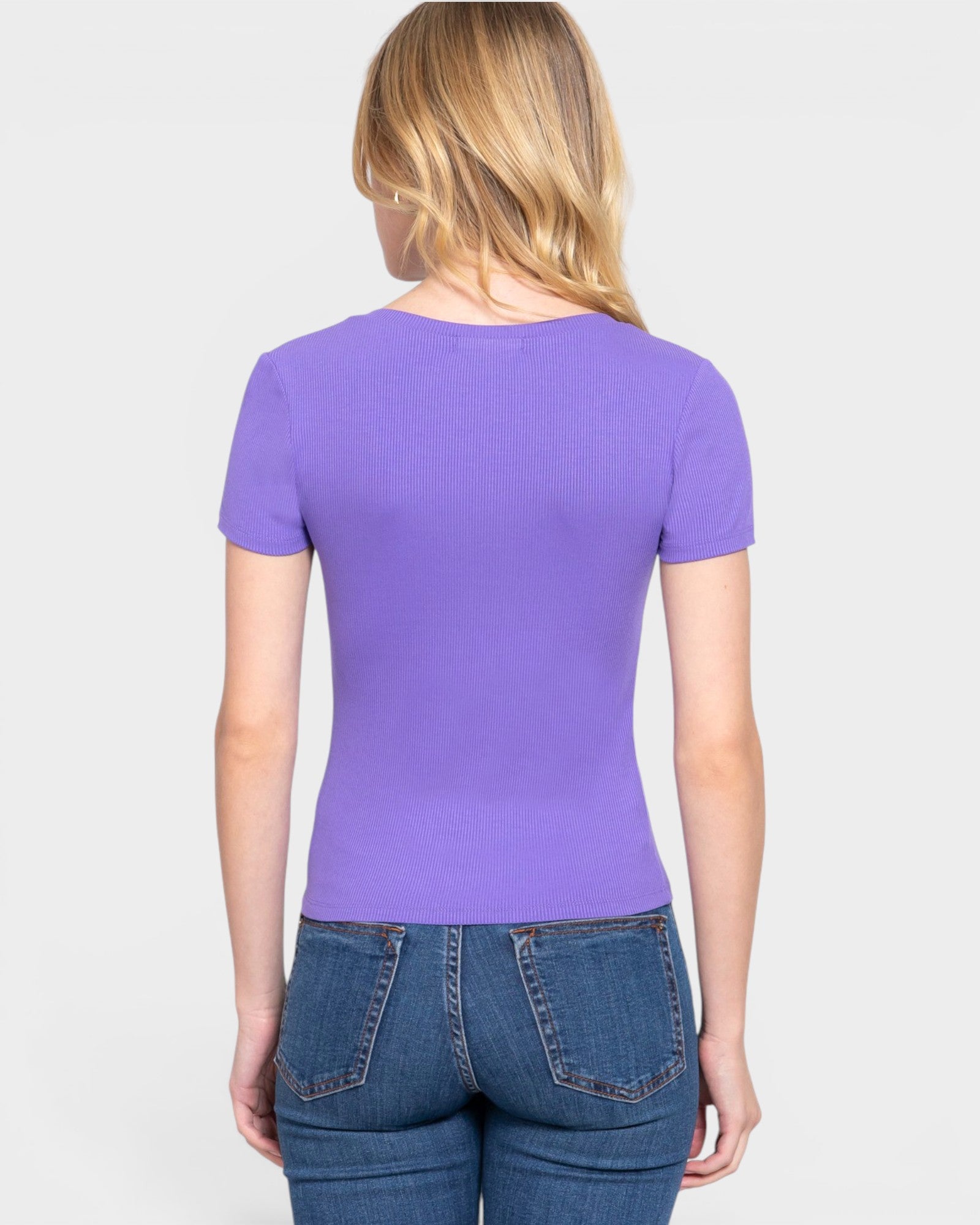 Person wearing a purple t-shirt and blue jeans on a white background