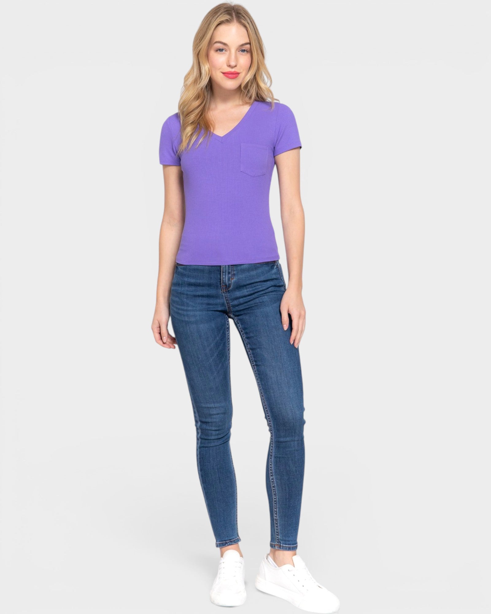 Woman wearing a purple t-shirt and blue jeans on a white background