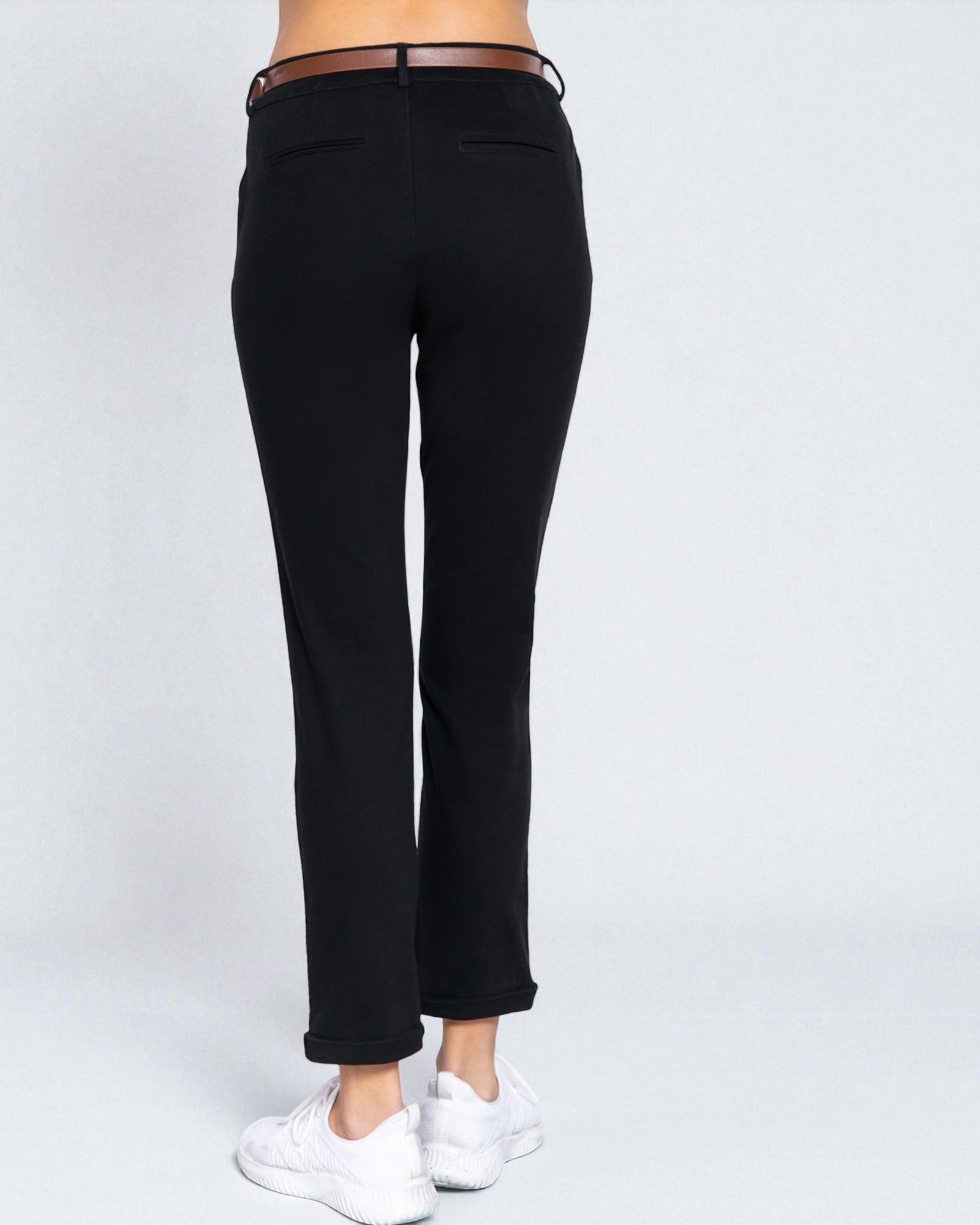 Black pants worn by a person on a white background