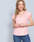 Woman wearing a pink top and blue jeans against a light gray background