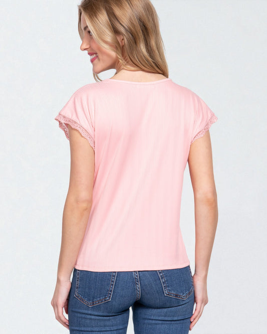 Woman wearing a pink t-shirt and blue jeans on a light gray background