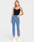 Woman wearing a black bodysuit and blue jeans against a white background