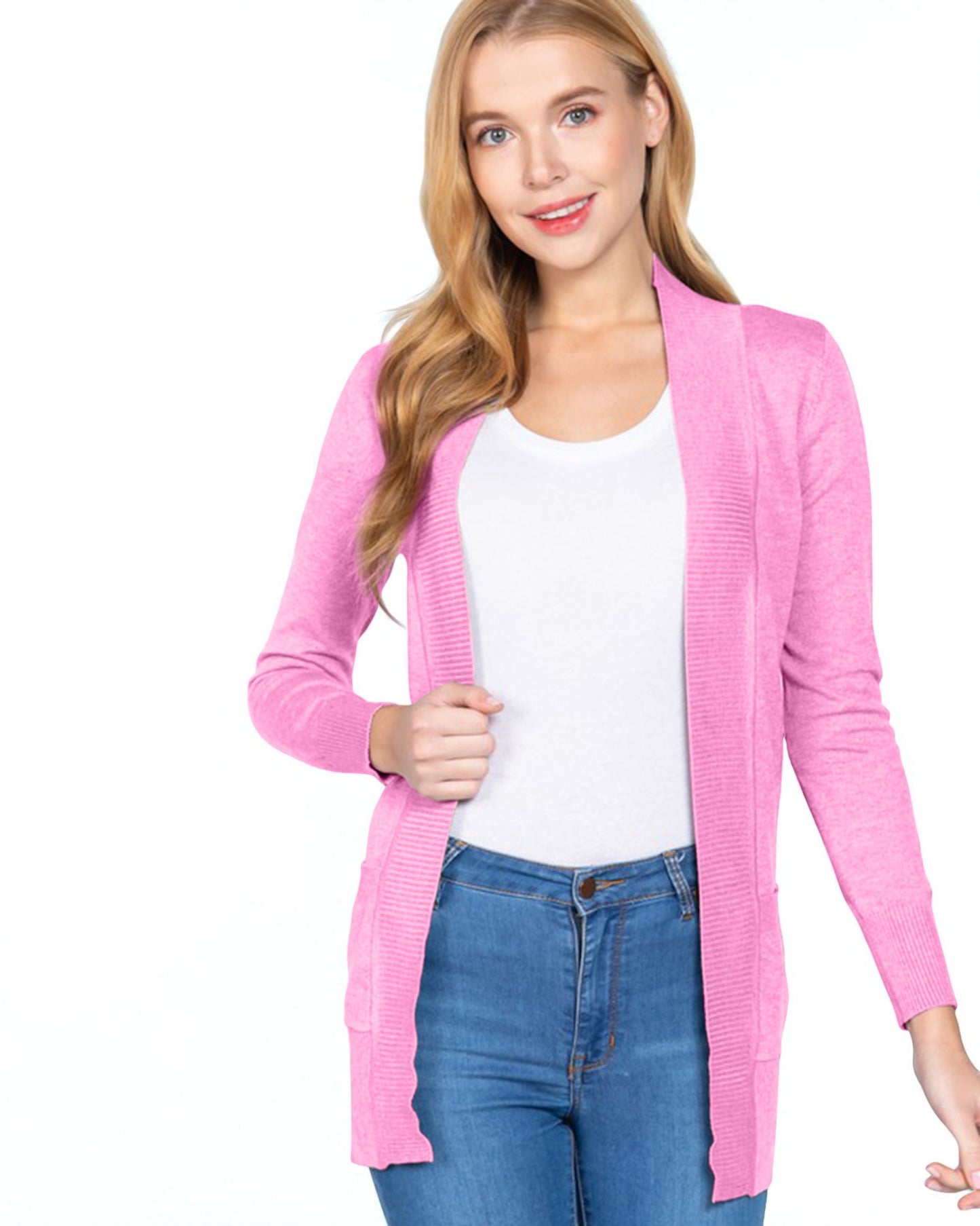 Woman wearing a pink cardigan over a white shirt and blue jeans on a white background