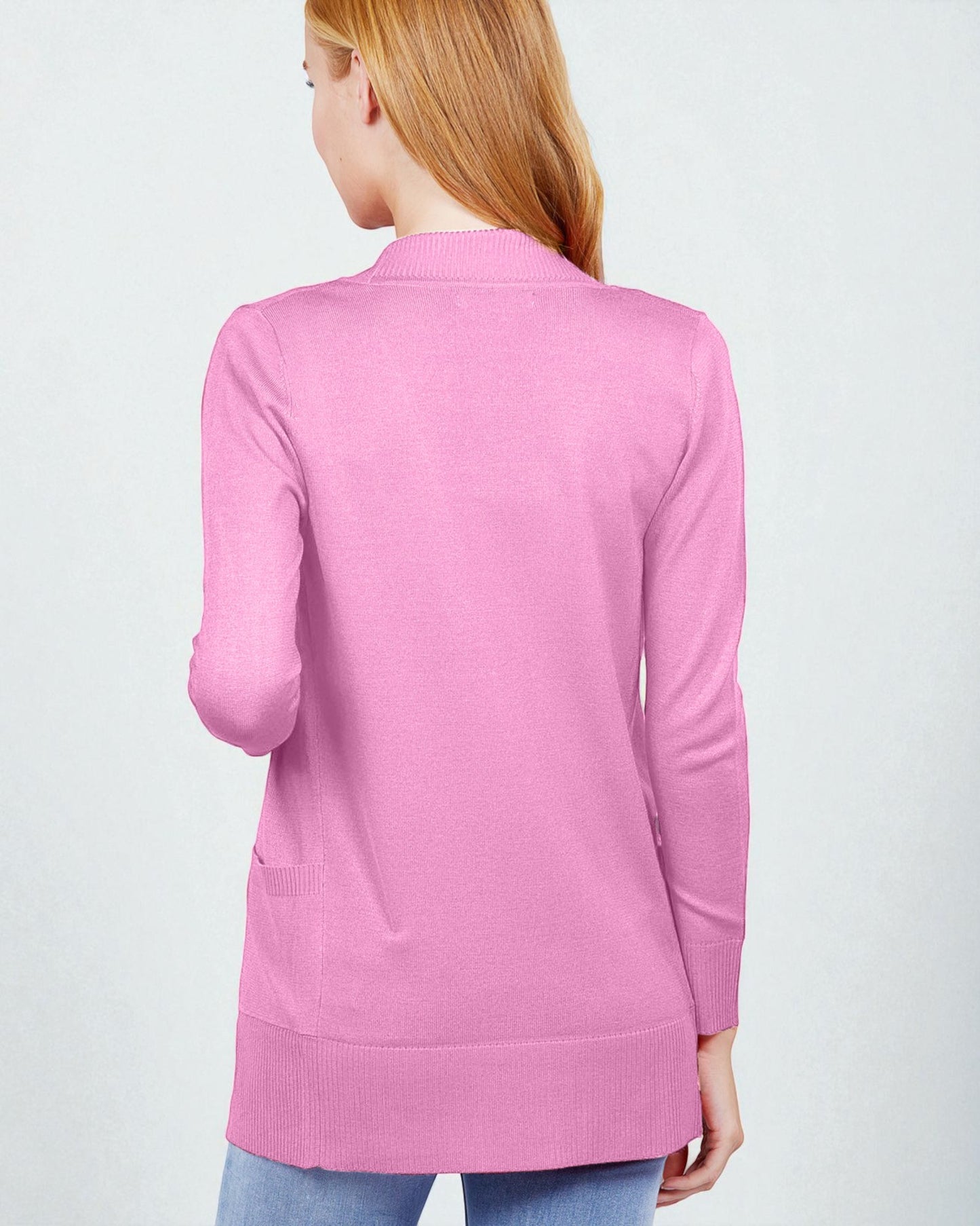 Pink sweater worn by a person on a light gray background